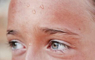 child in heatwave with sweat dripping down her forehead