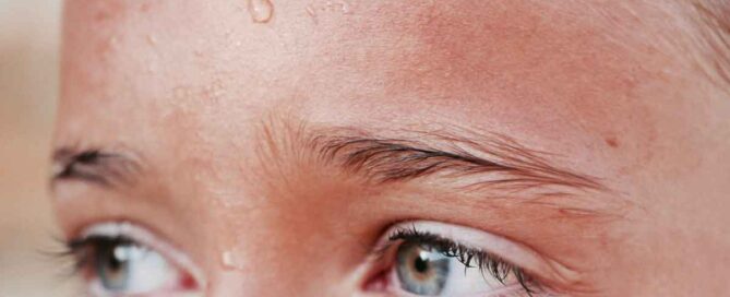 child in heatwave with sweat dripping down her forehead