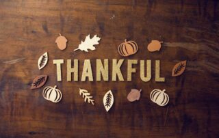 fall scene with letters spelling the word thankful